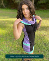 Organic cotton sleeveless hooded dress, black with lavender fabric accents, right front side view on female model.