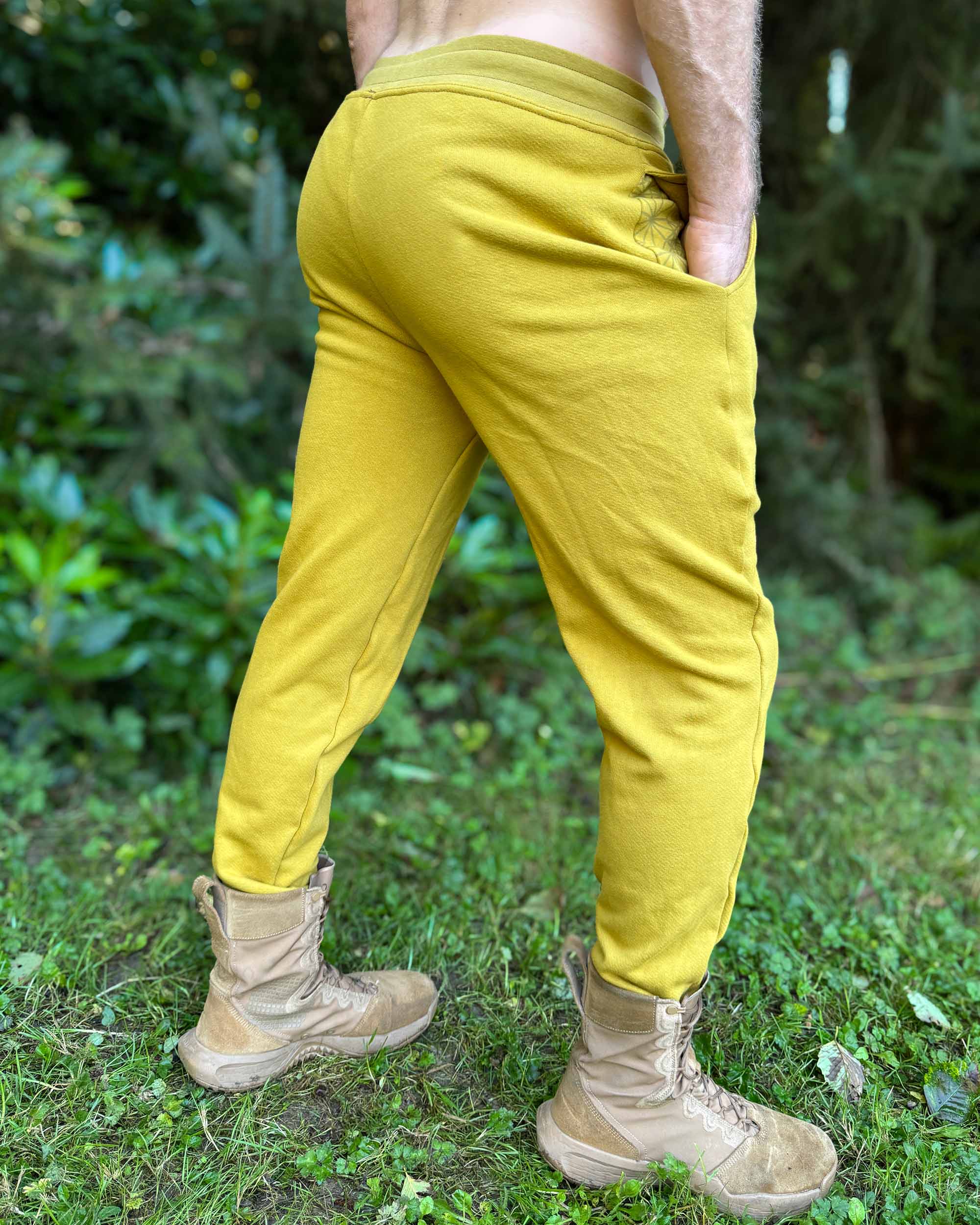 Organic cotton fleece joggers, solid yellow fabric, back side view on male model.