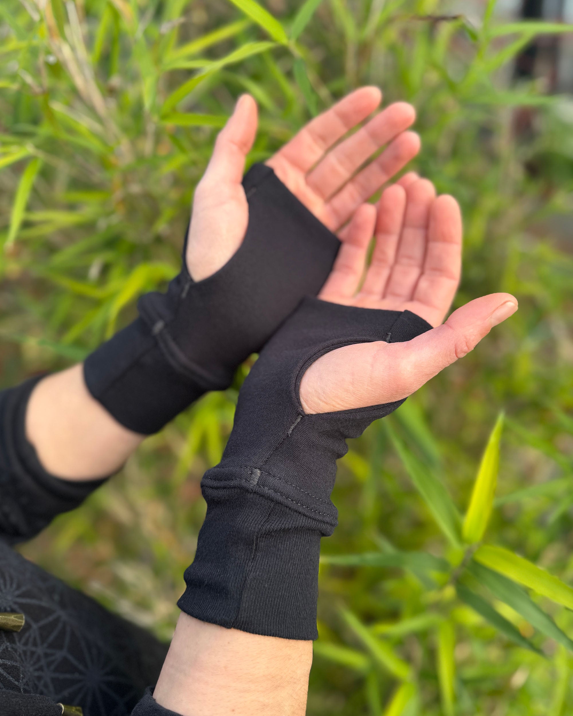 organic cotton hand warmers made in black solid fabric with natural background.