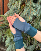 Female hands wearing dark blue organic cotton hand warmers.