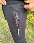 Black organic cotton joggers with geometric design inside pocket detail.