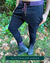 Organic cotton unisex joggers, black fabric with brown accents, front view on male model.