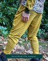 Organic cotton unisex joggers, yellow fabric with brown geometric print, back left side view on male model.