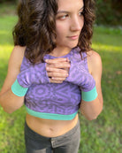 Organic cotton fingerless gloves in lavender fabric and geometric print, front view worn by female model.