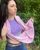 Organic cotton infinity scarf, pink fabric with geometric stripes, right side view on female model. 