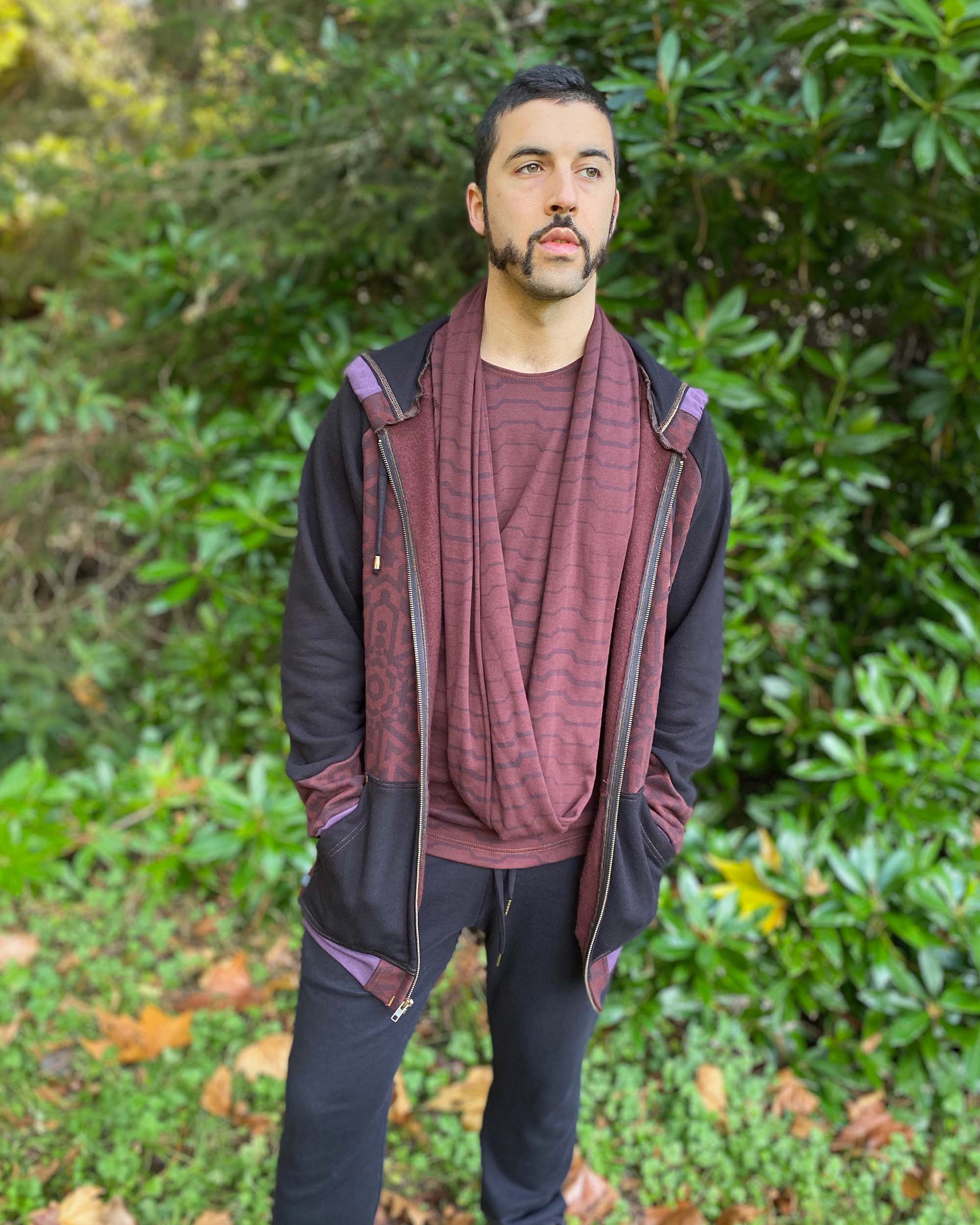 Organic cotton infinity scarf, brown fabric with geometric stripes, front view on male model in nature. 