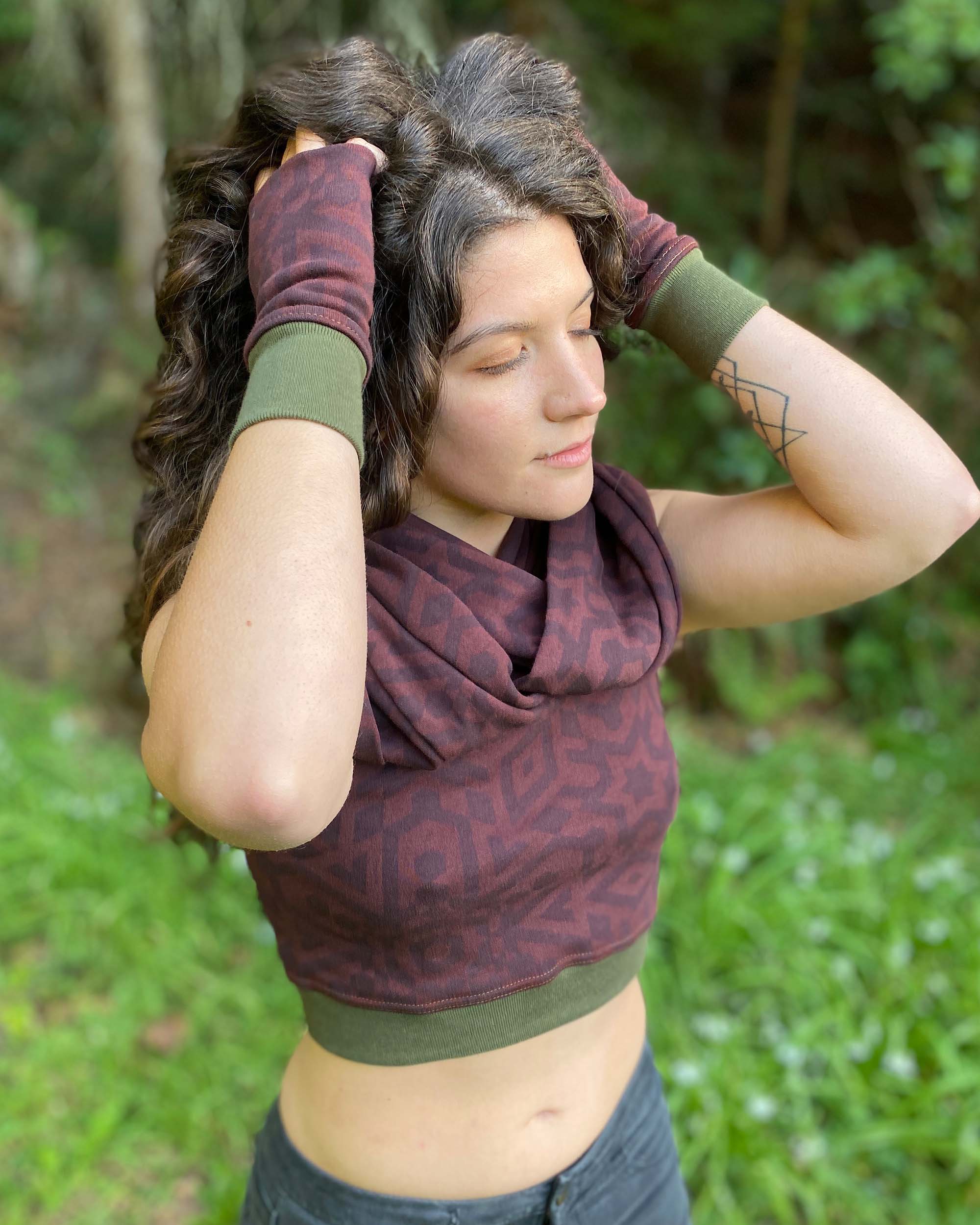 Organic cotton infinity scarf, brown fabric with geometric print and matching crop top, right side view on female model. 