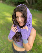Female model wearing matching set of crop top, infinity scarf and fingerless gloves, purple organic cotton fabric with geometric print, front side view.