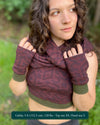 Female model wearing matching set of crop top, infinity scarf and fingerless gloves, brown organic cotton fabric with geometric print, front view.