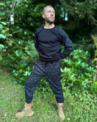 Men's matching joggers and long sleeve shirt, black with geometric printed accent fabric, worn by male model.