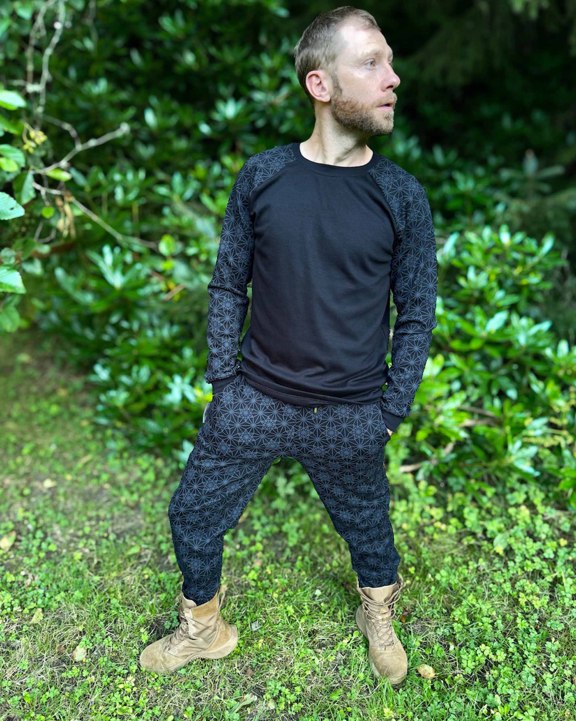 Men's matching joggers and long sleeve shirt, black with geometric printed accent fabric, front view on  male model.
