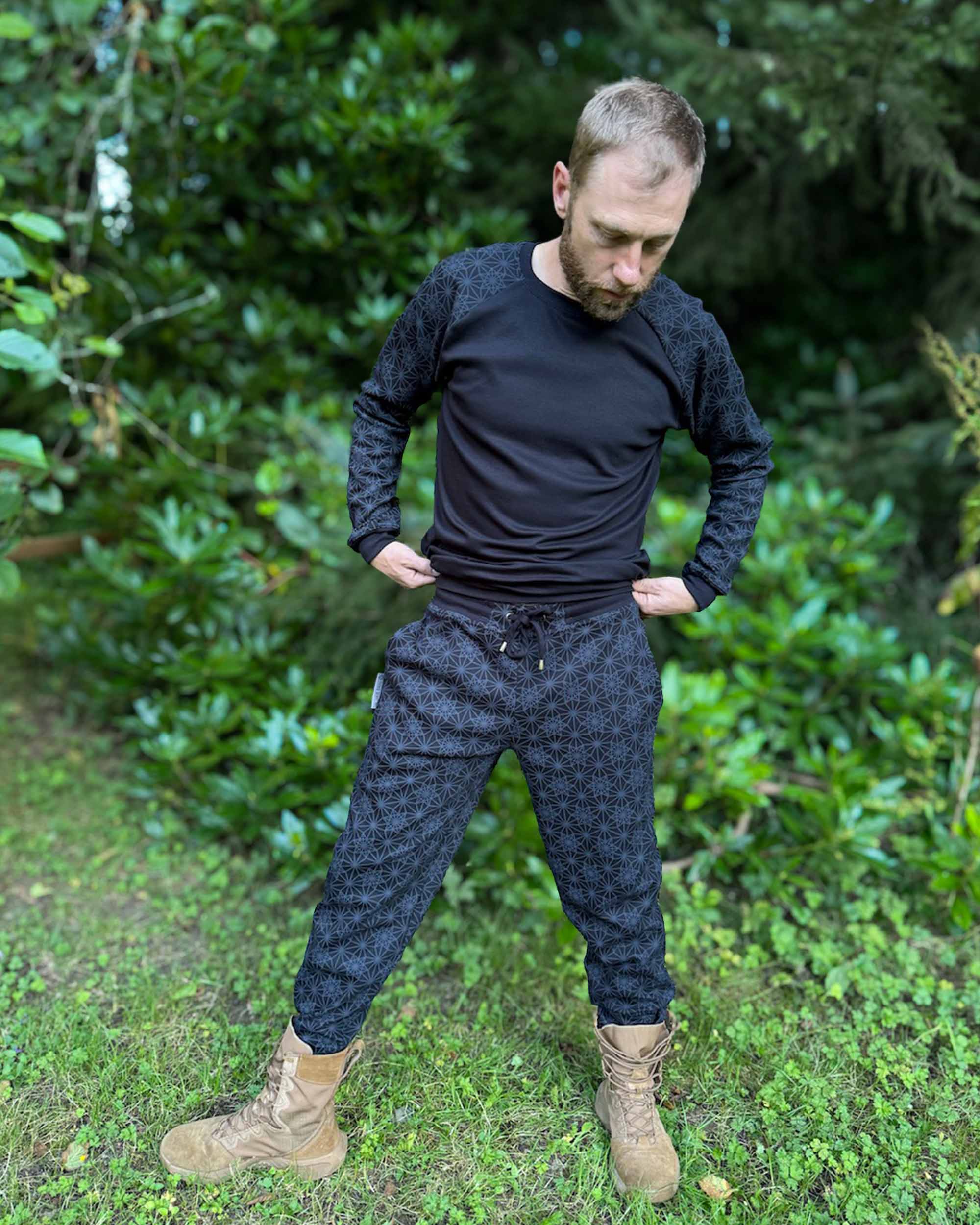 Matching joggers and long sleeve shirt, black with geometric printed accent fabric, worn by male model.