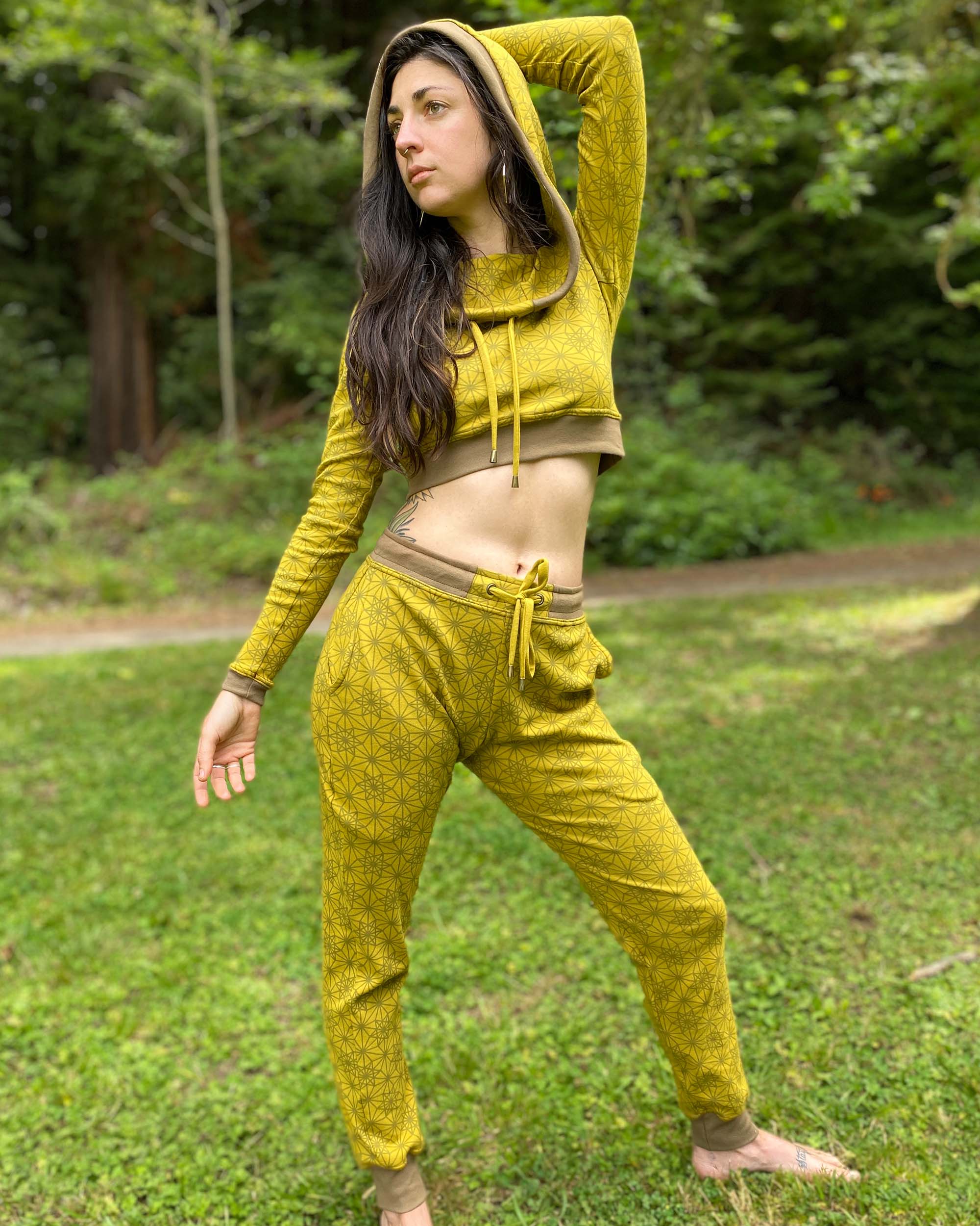 Women's matching two piece outfit, joggers and crop hoodie, yellow fabric with geometric print, full body view on female model.
