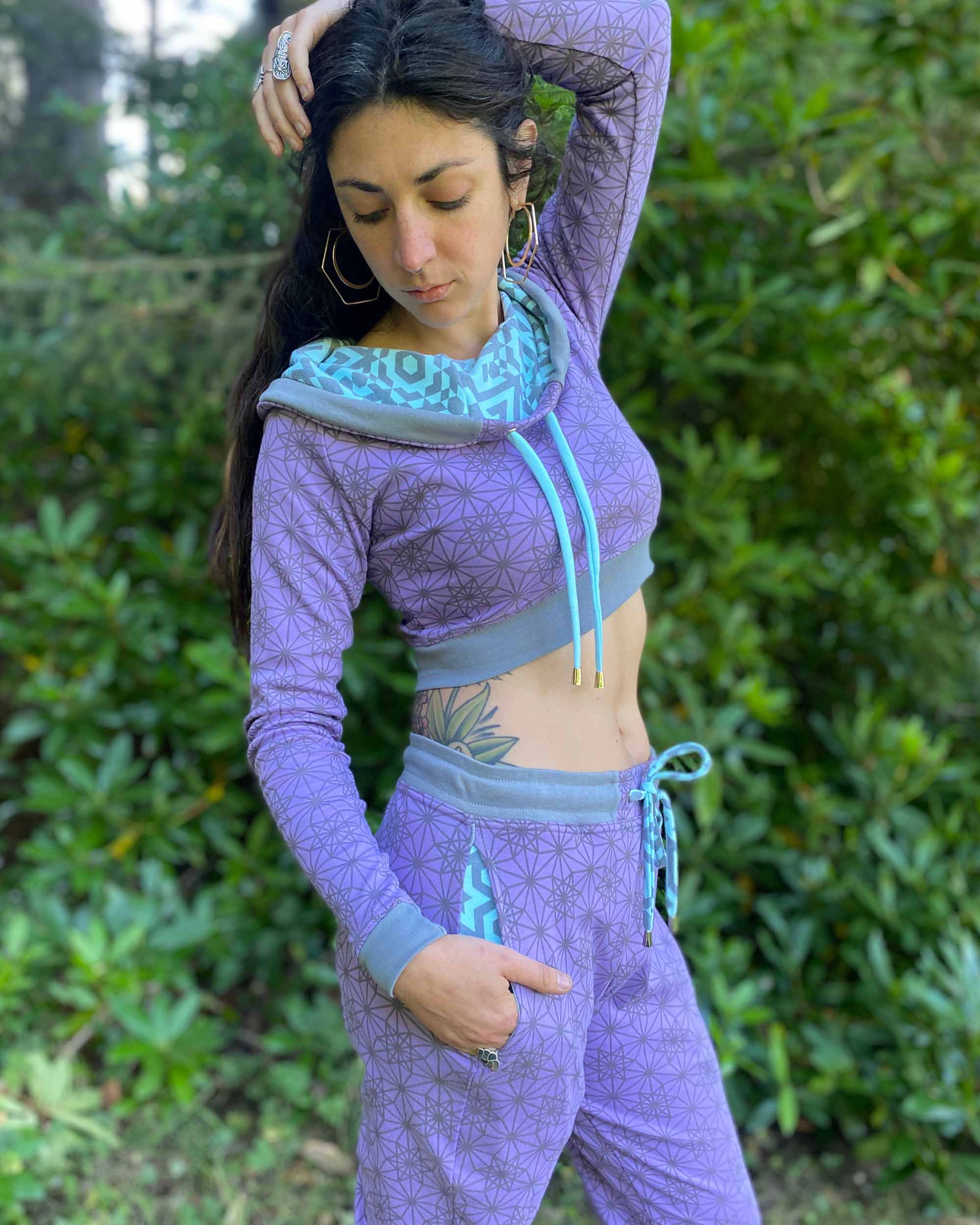 Matching two piece set, joggers and crop hoodie, lavender with geometric printed fabric, right side view on model.