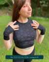 Organic cotton crop top, black fabric with sacred geometry print, front view on female model.
