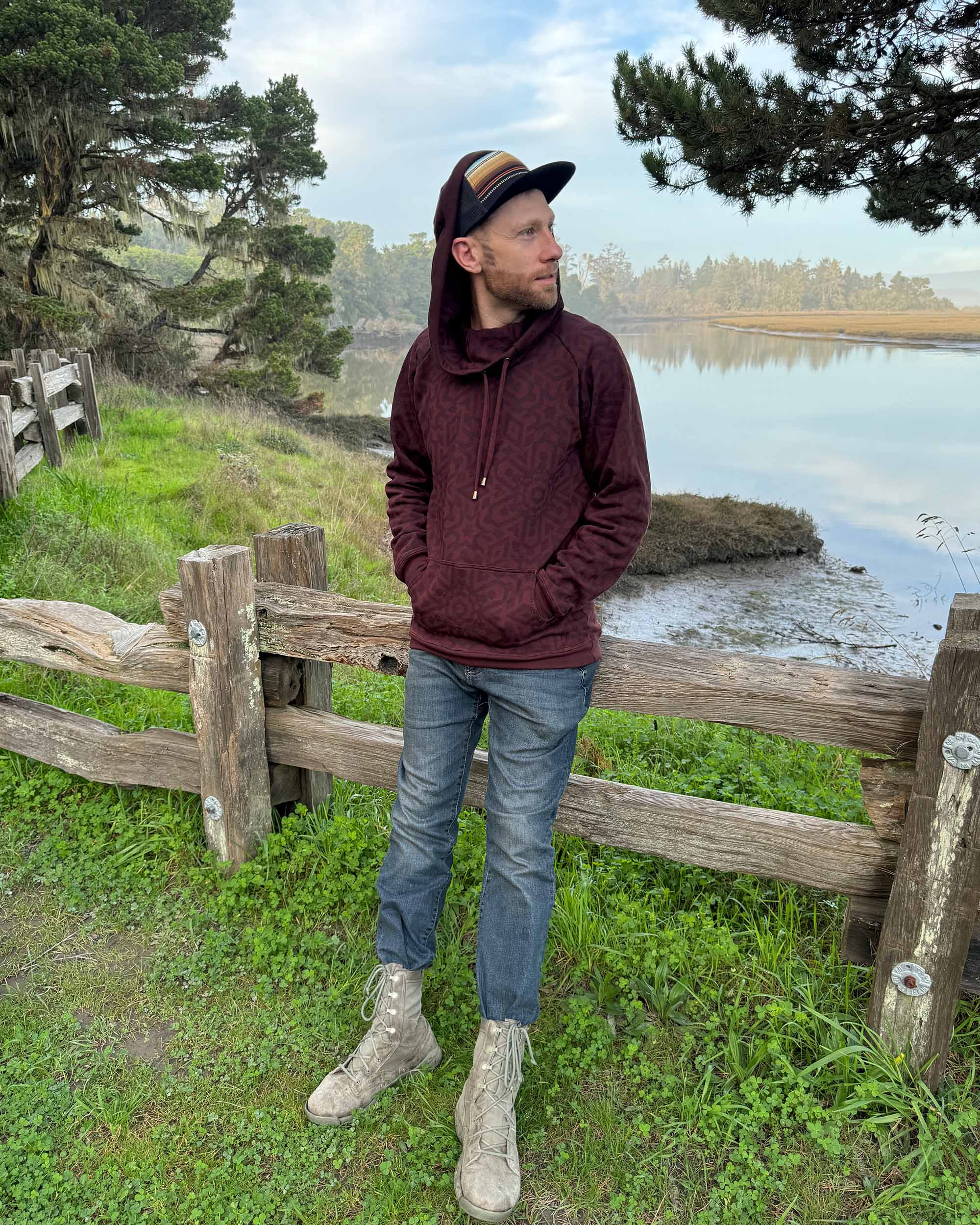 Organic cotton fleece unisex hoodie, reddish brown fabric with geometric print, full body view on male model.