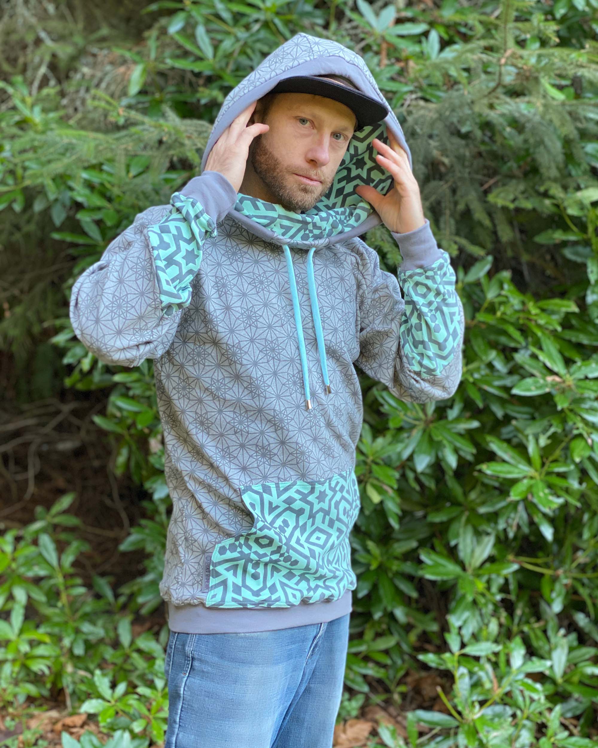 Organic cotton extra long unisex hoodie, grey with geo print, front right side view.