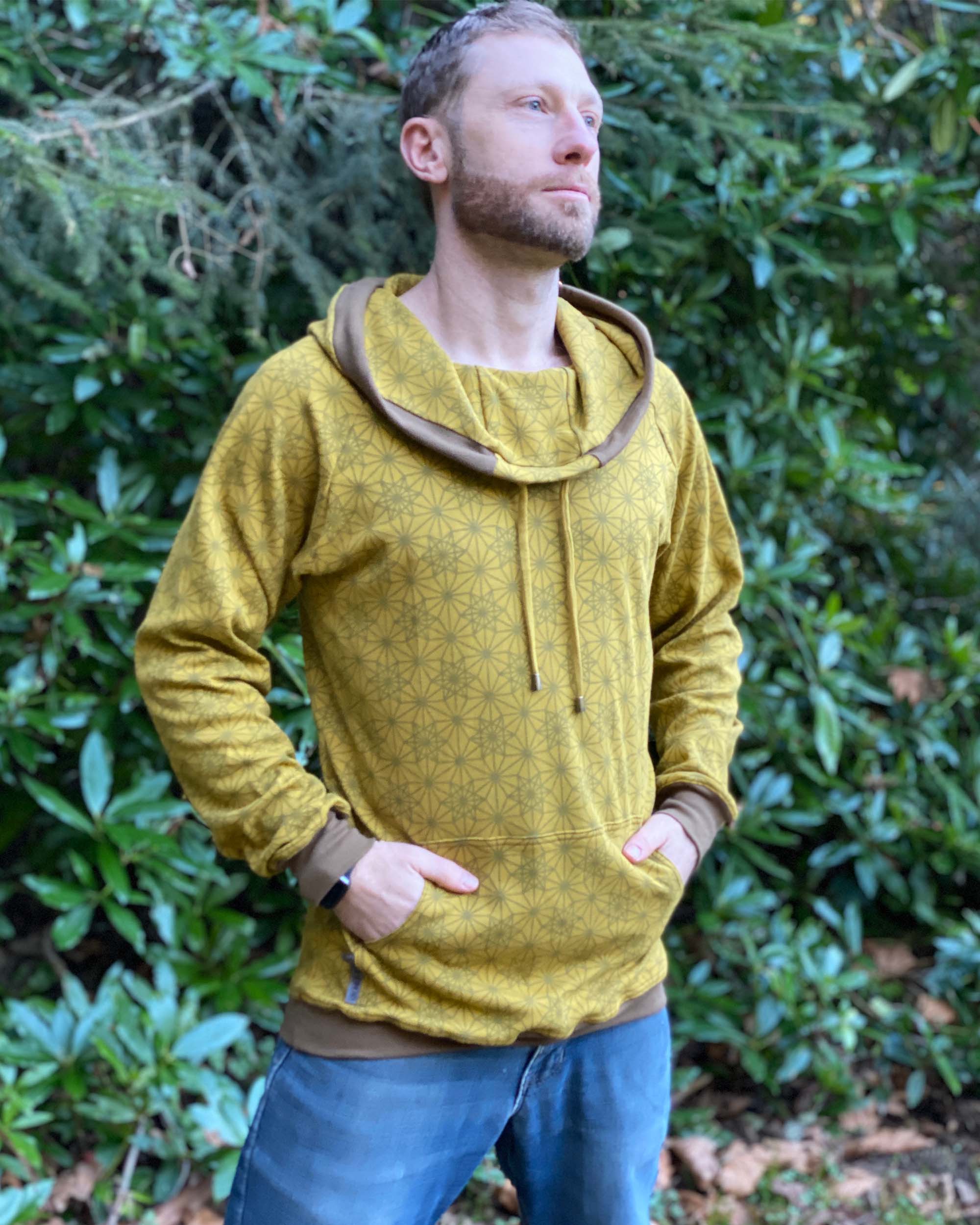 Organic cotton extra long unisex hoodie, yellow fabric with geo print, front view of male model.