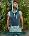Organic cotton sleeveless hoodie, deep blue with mint geometric print accent fabric, front view on male model.
