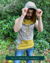 Organic cotton hooded tank top, undyed with brown geometric print, front side view on male model.