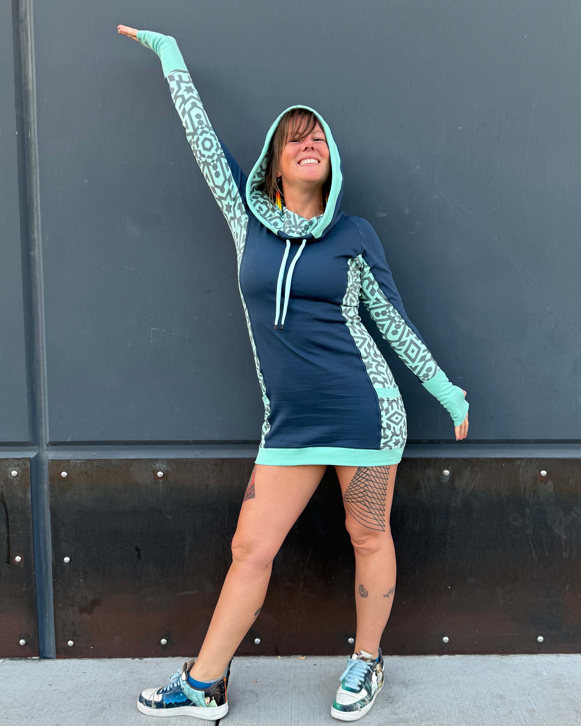 Organic cotton hooded tunic dress, blue with geometric mint fabric, front view on model.