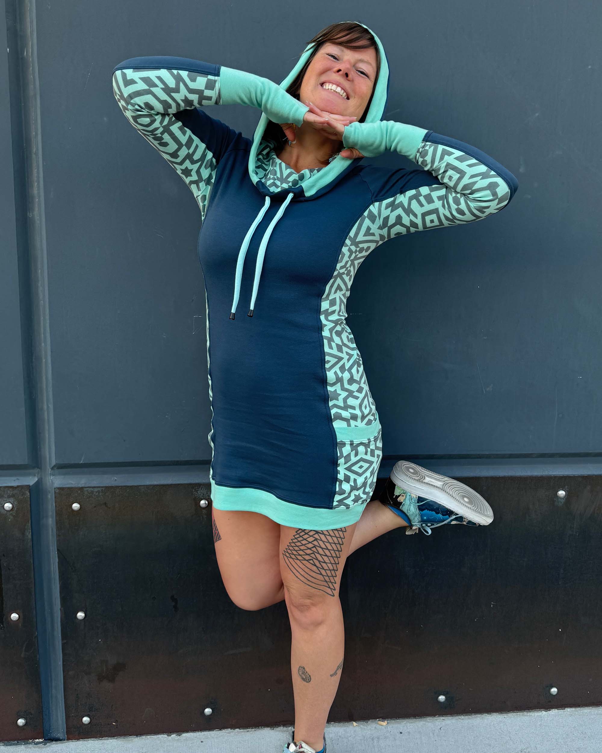 Organic cotton hooded tunic dress, blue with geometric mint fabric accents, worn by female model.