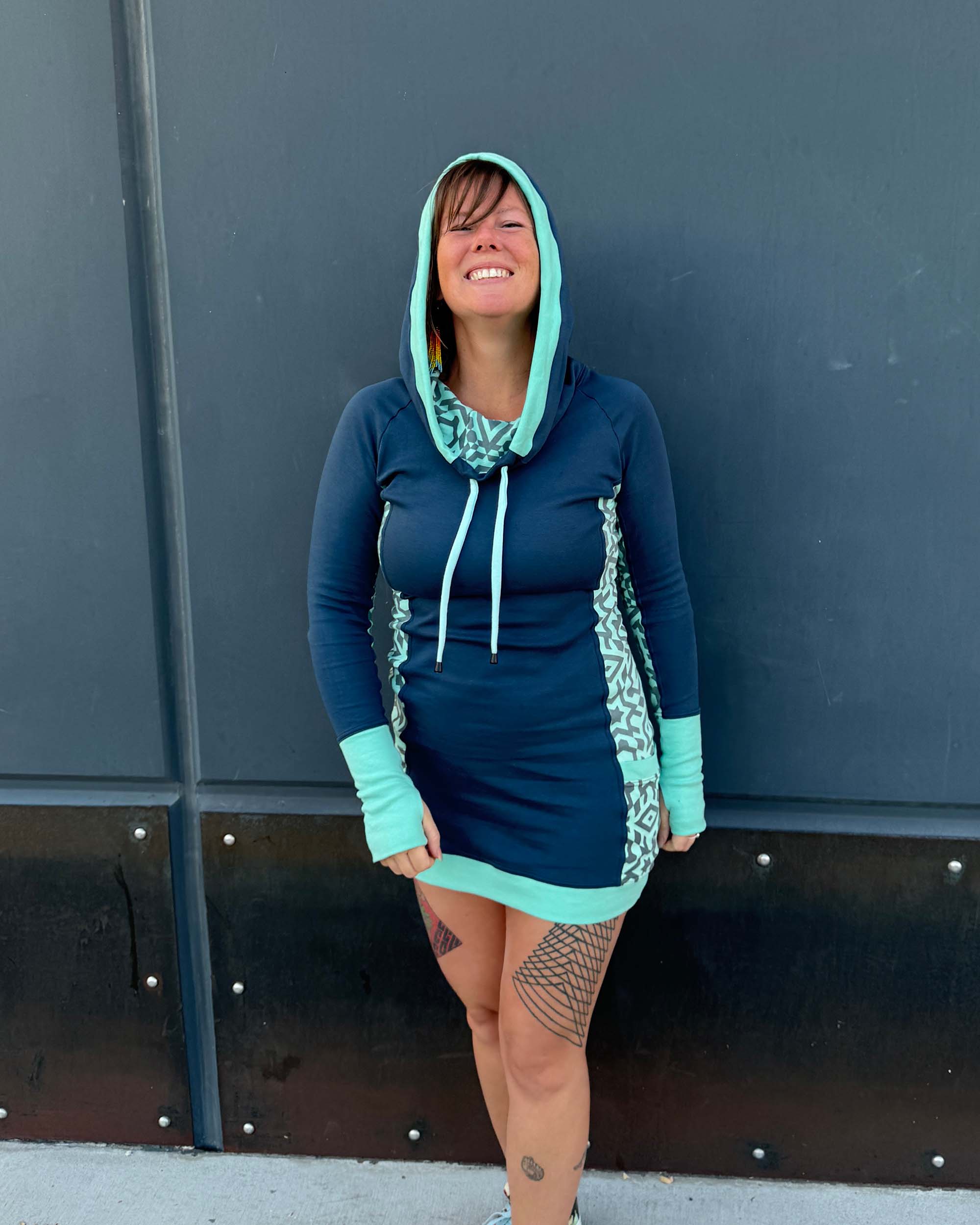 Organic cotton hooded tunic dress, blue with sacred geometry fabric accents, front view on model.