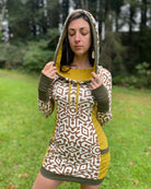 Organic cotton hooded tunic dress, undyed and yellow fabric with geometric print, front view on model with hood up.