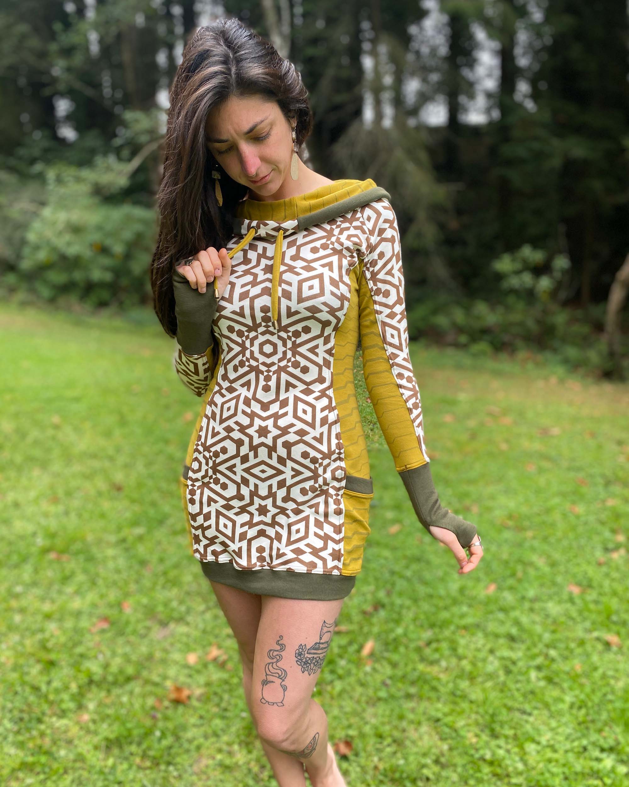 Organic cotton hooded tunic dress, undyed fabric with brown geo print and yellow accents, front view on model.