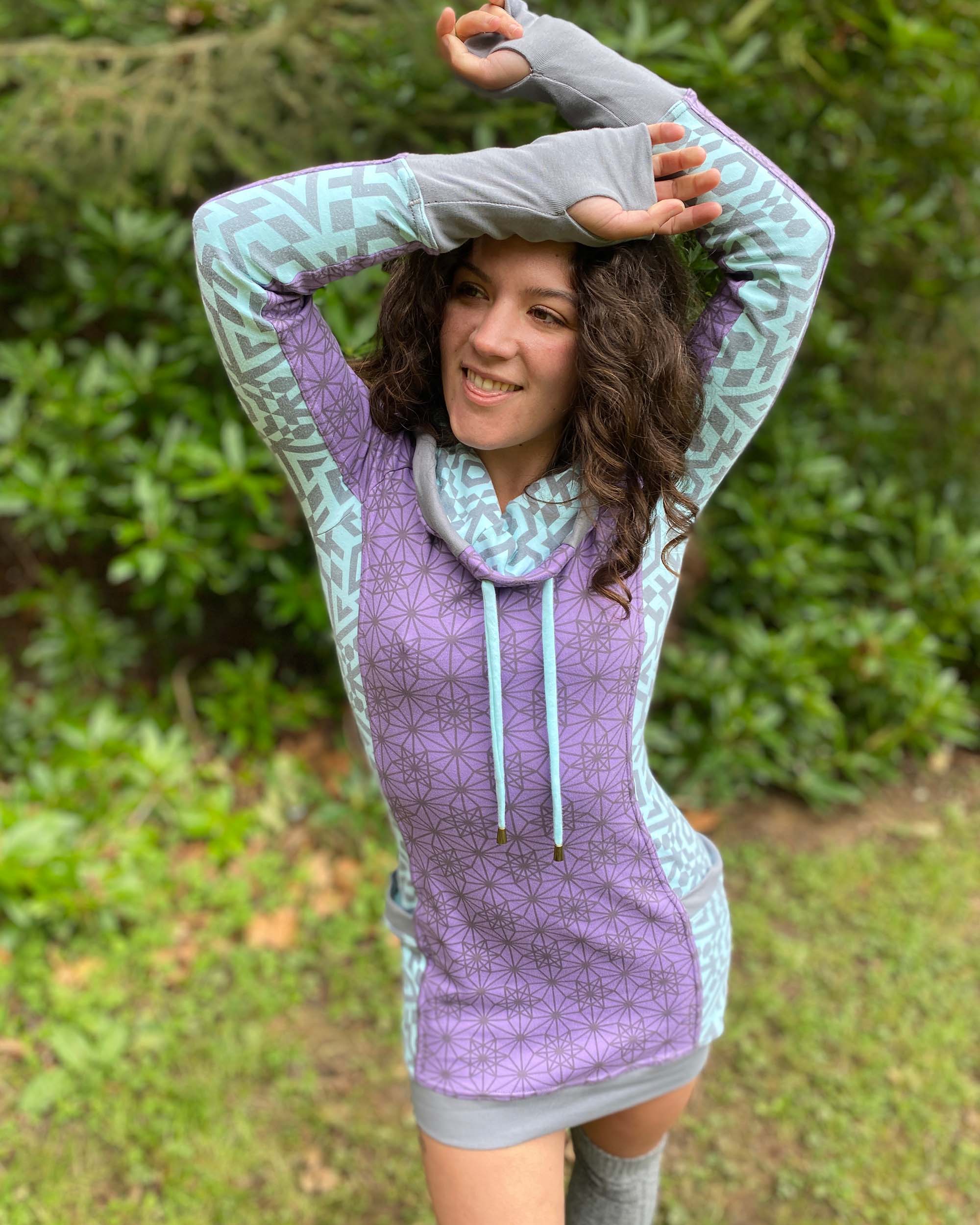 Organic cotton hooded tunic dress, lavender and mint fabric with geometric print, front side view on model.
