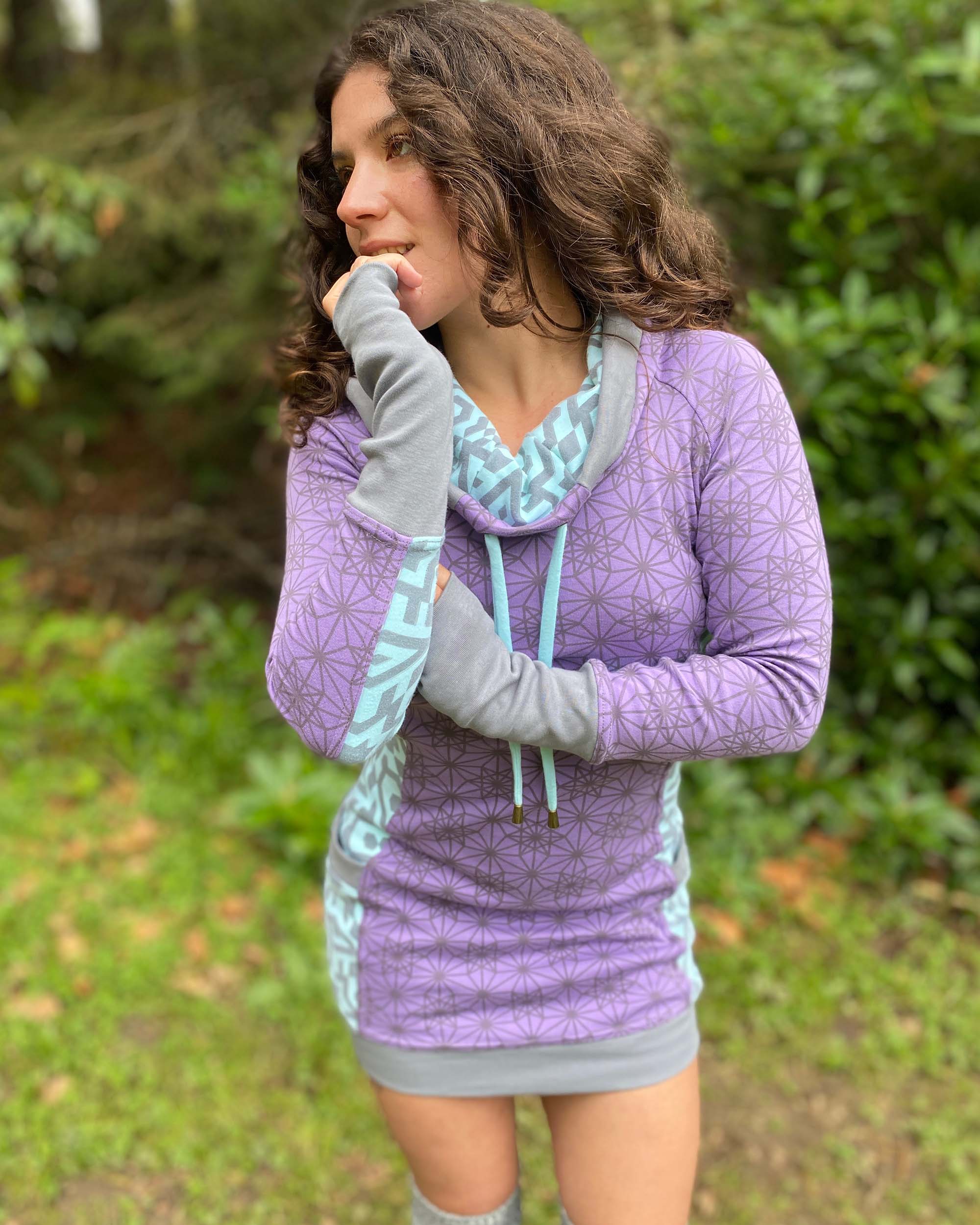 Organic cotton hooded tunic dress, lavender and mint fabric with geometric print, close up on fabric.