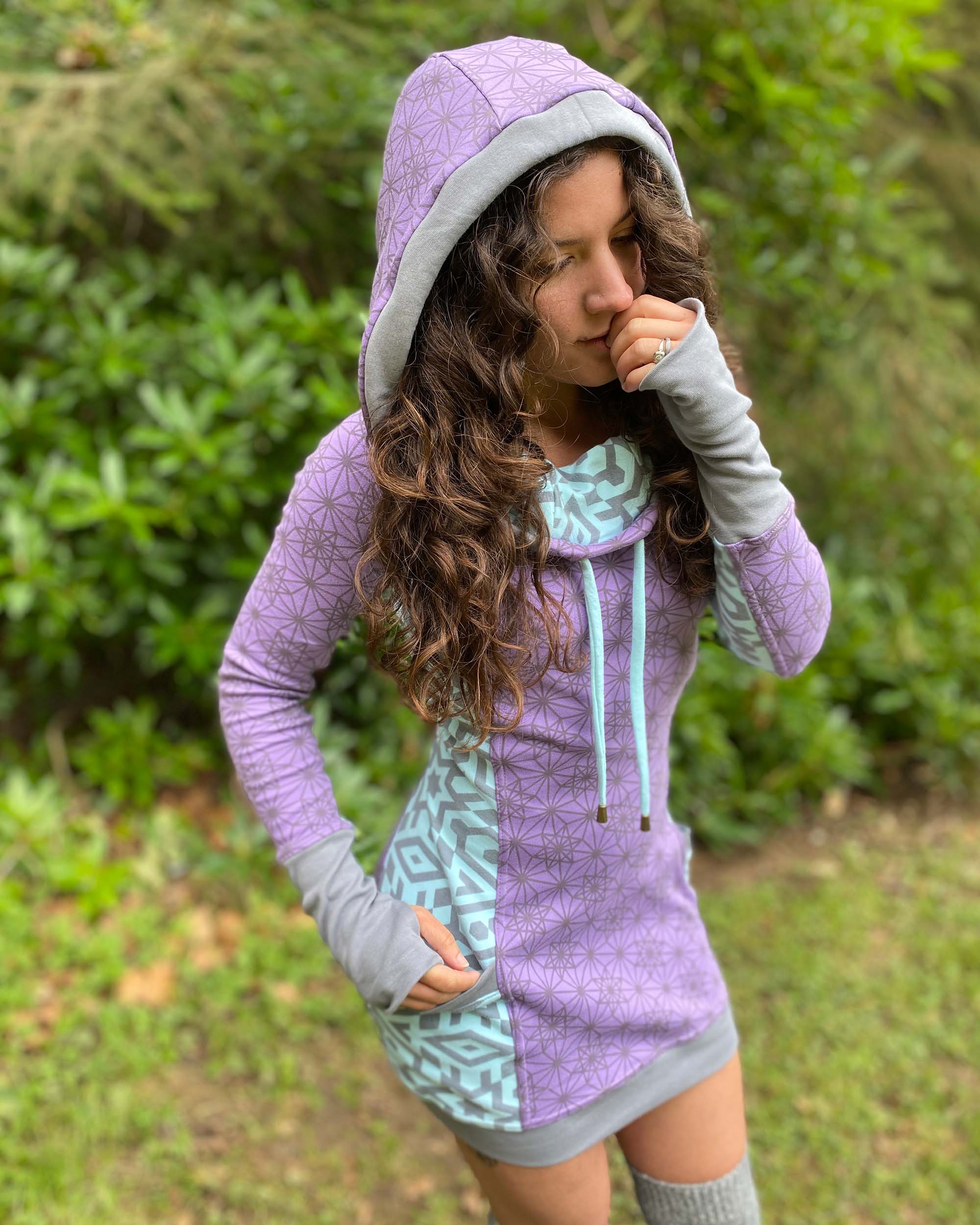 Organic cotton hooded dress, lavender and mint fabric with geometric print, front view of model.