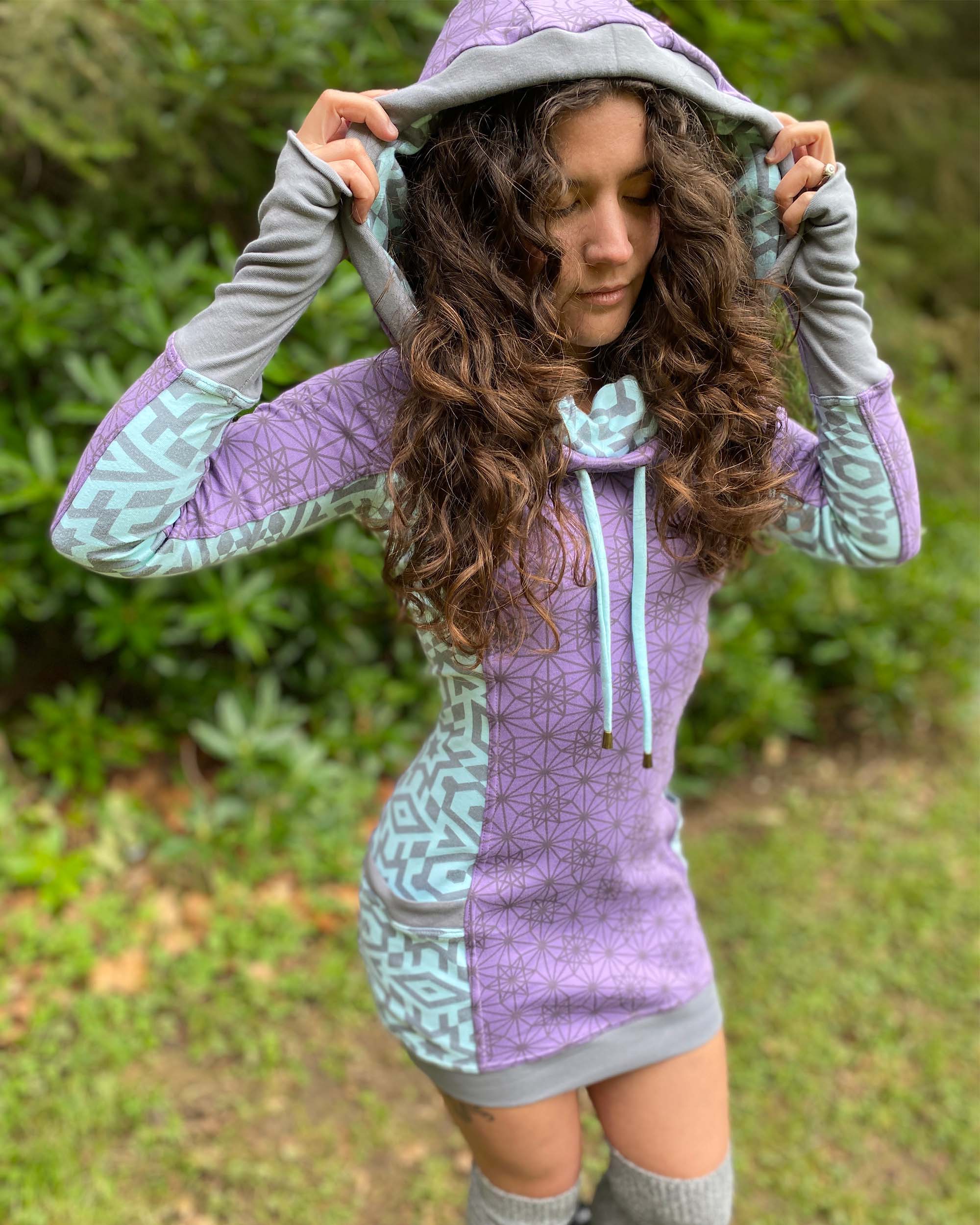 Organic cotton hooded tunic dress, lavender and mint fabric with geometric print, right side view on model.