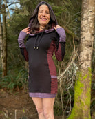 Organic cotton hooded tunic dress, black with geometric reddish brown fabric accents, front view on model.