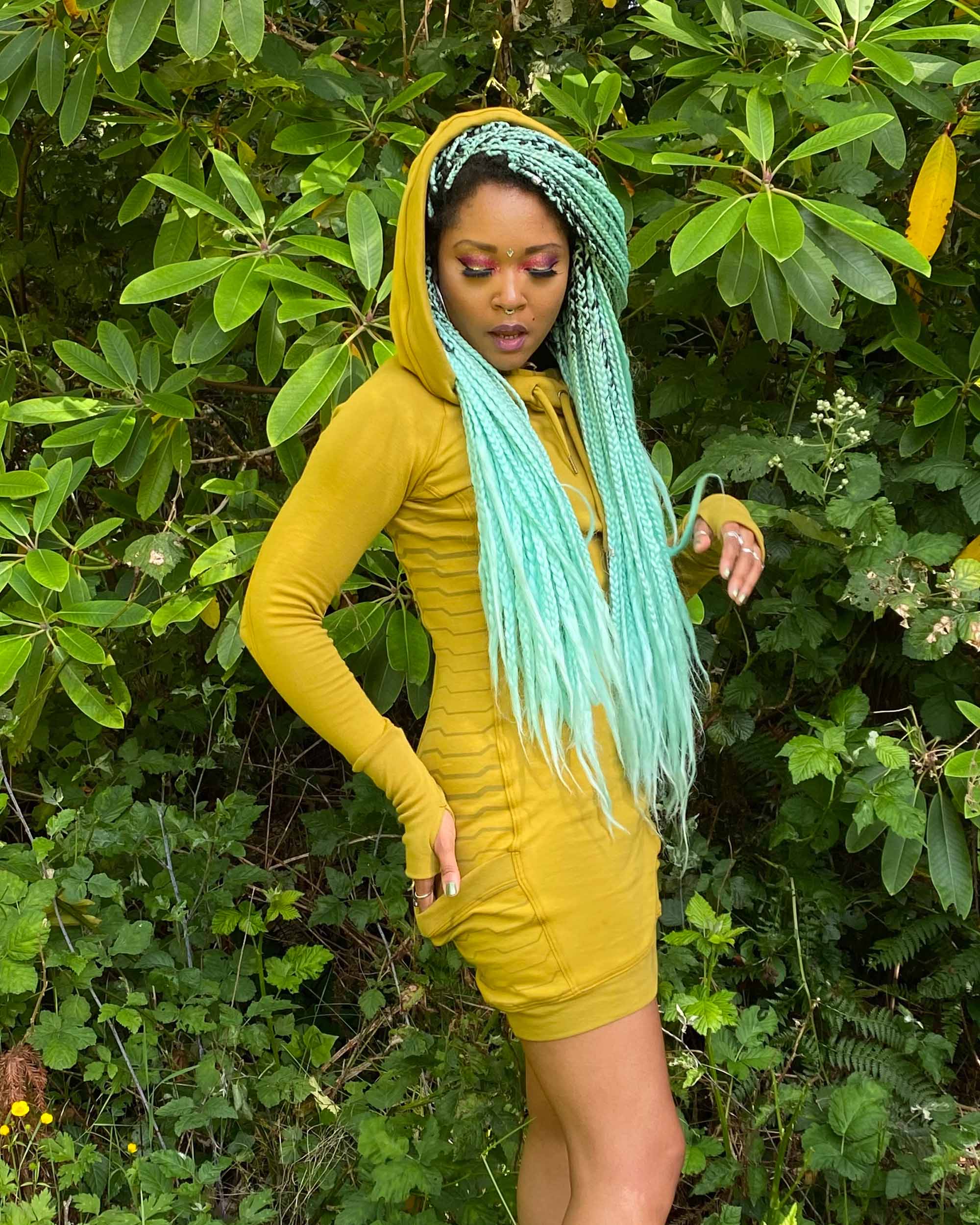 Organic cotton hooded tunic dress, yellow fabric with geometric print, right front side view on model.