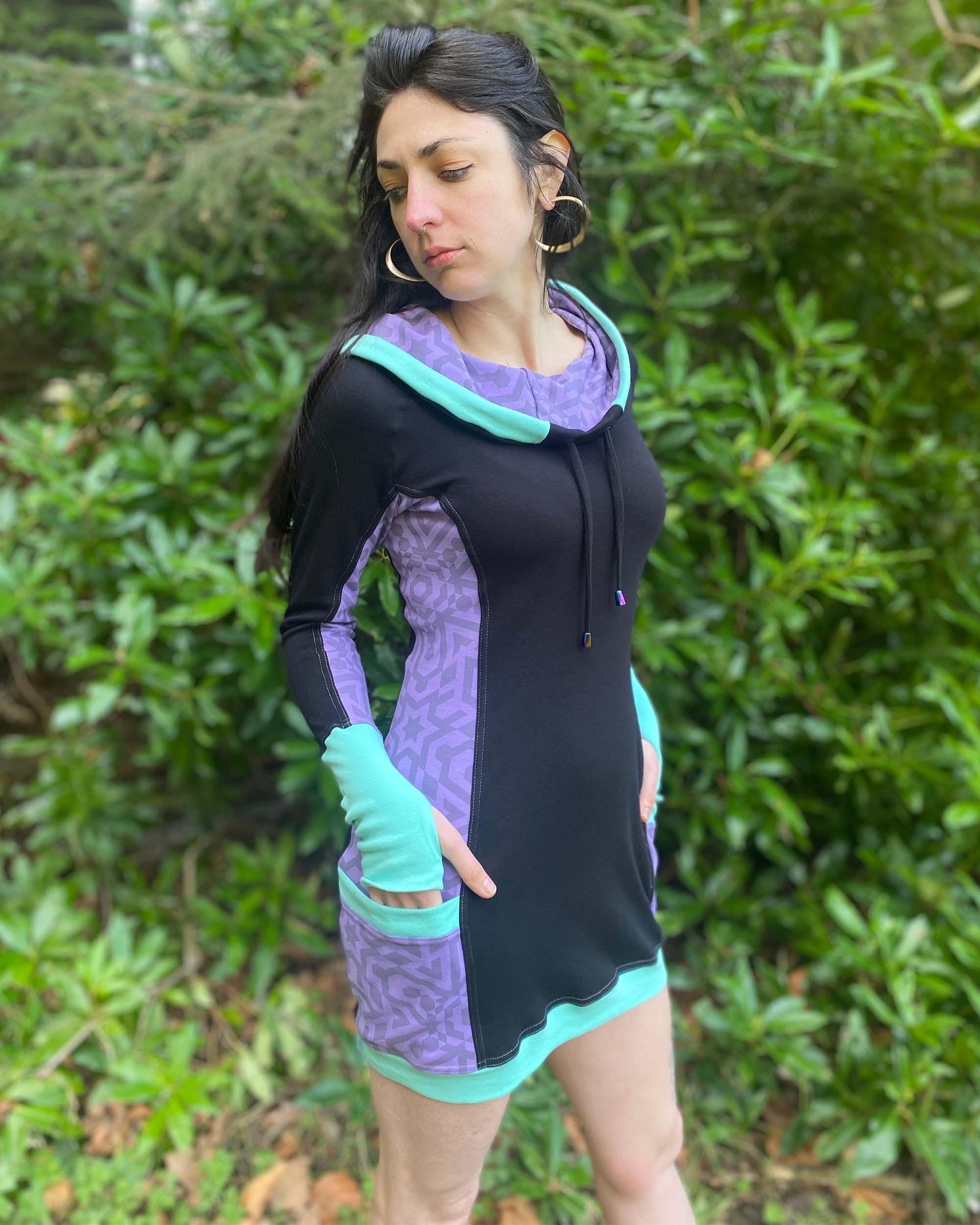Organic cotton hooded tunic dress, black and lavender fabric with geometric print, right side view on model.