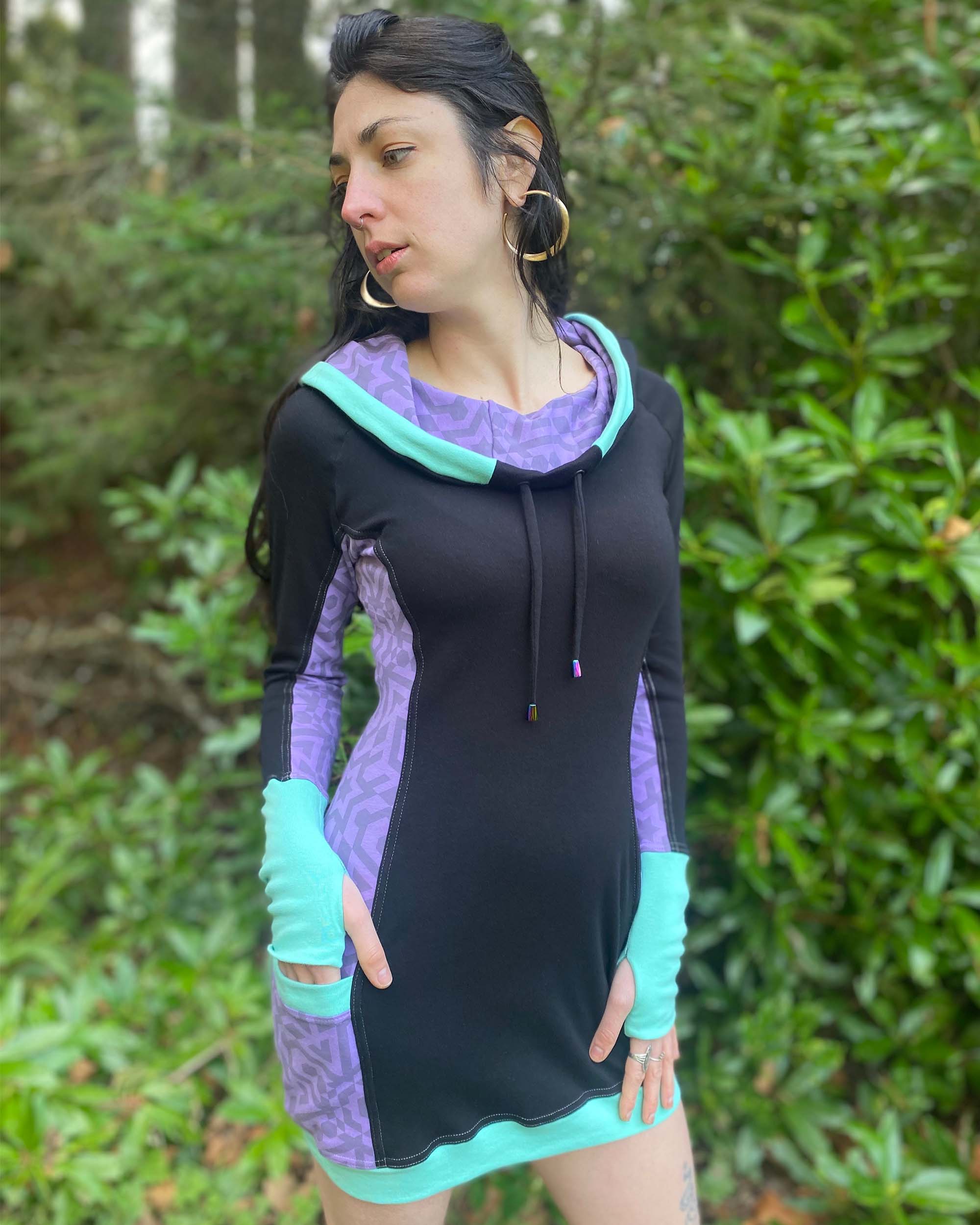 Organic cotton hooded tunic dress, black and lavender fabric with geometric print, front right view on model.