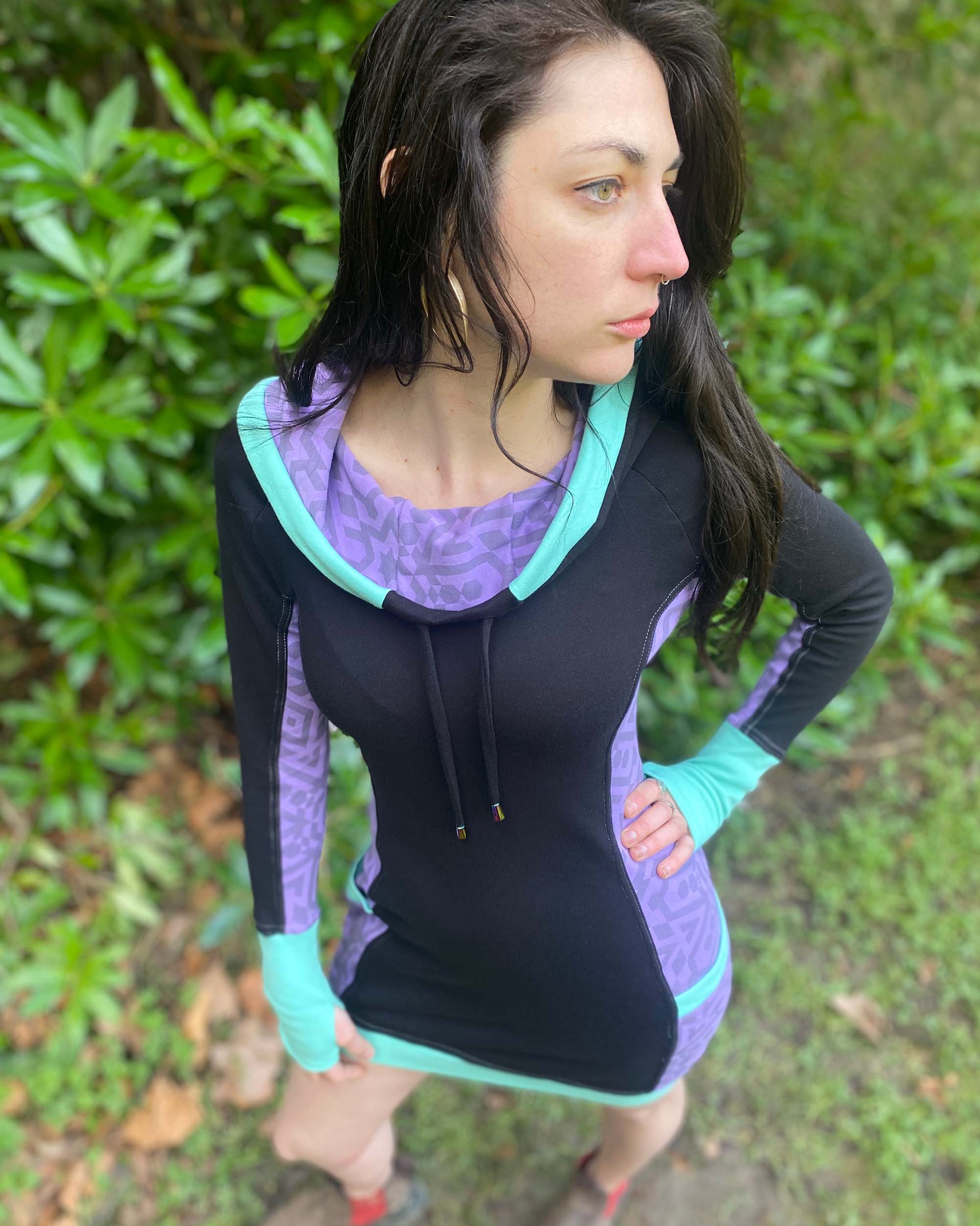 Organic cotton hooded tunic dress, black and lavender fabric with geometric print, top view on model.