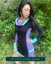 Organic cotton hooded tunic dress, black and lavender fabric with geometric print, left side view on model.