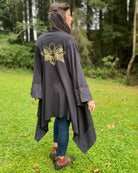 Organic cotton kimono, black fabric with gold lotus print on back, worn by female model.