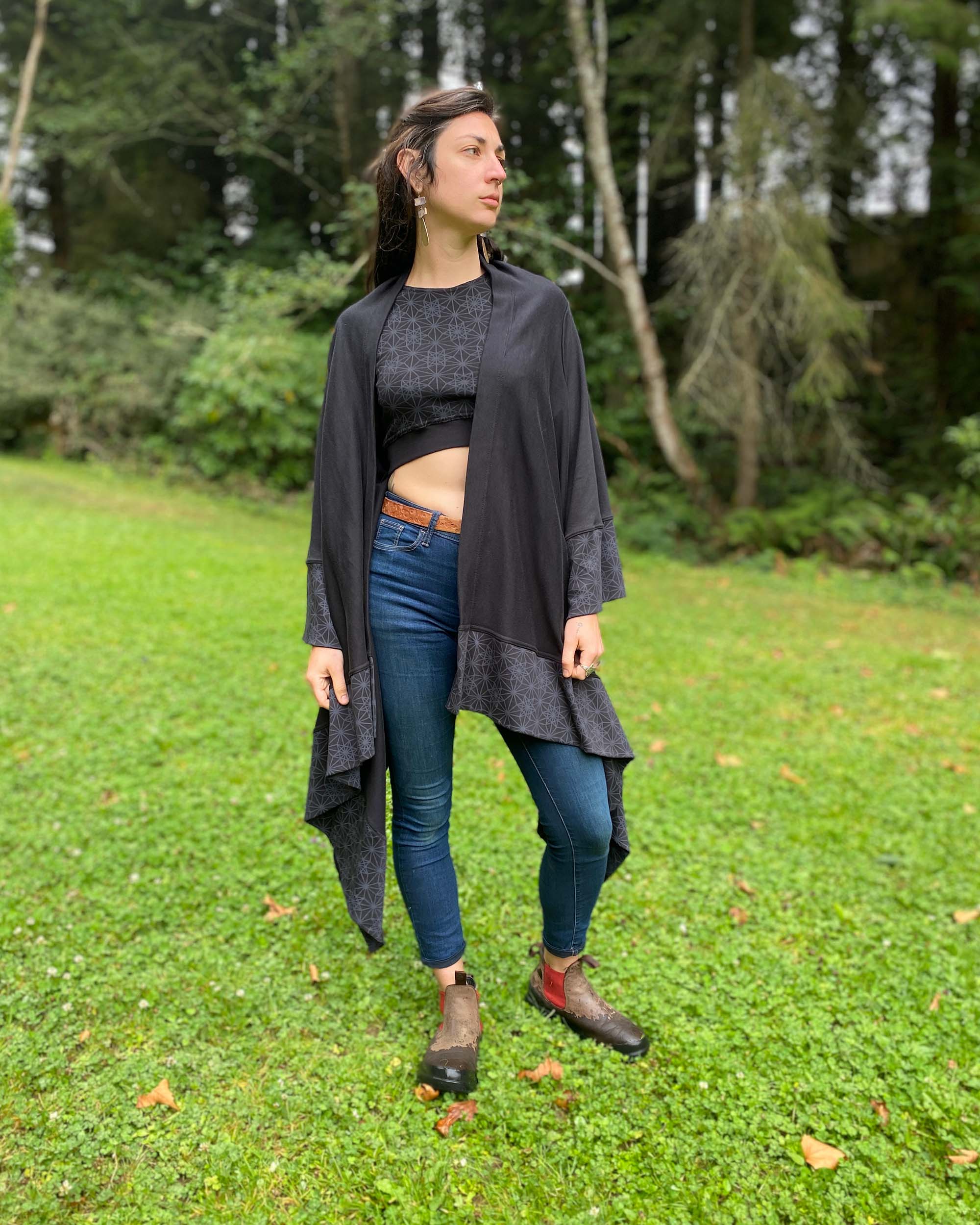 Organic cotton kimono, black fabric with geometric printed accents, front view on female model.