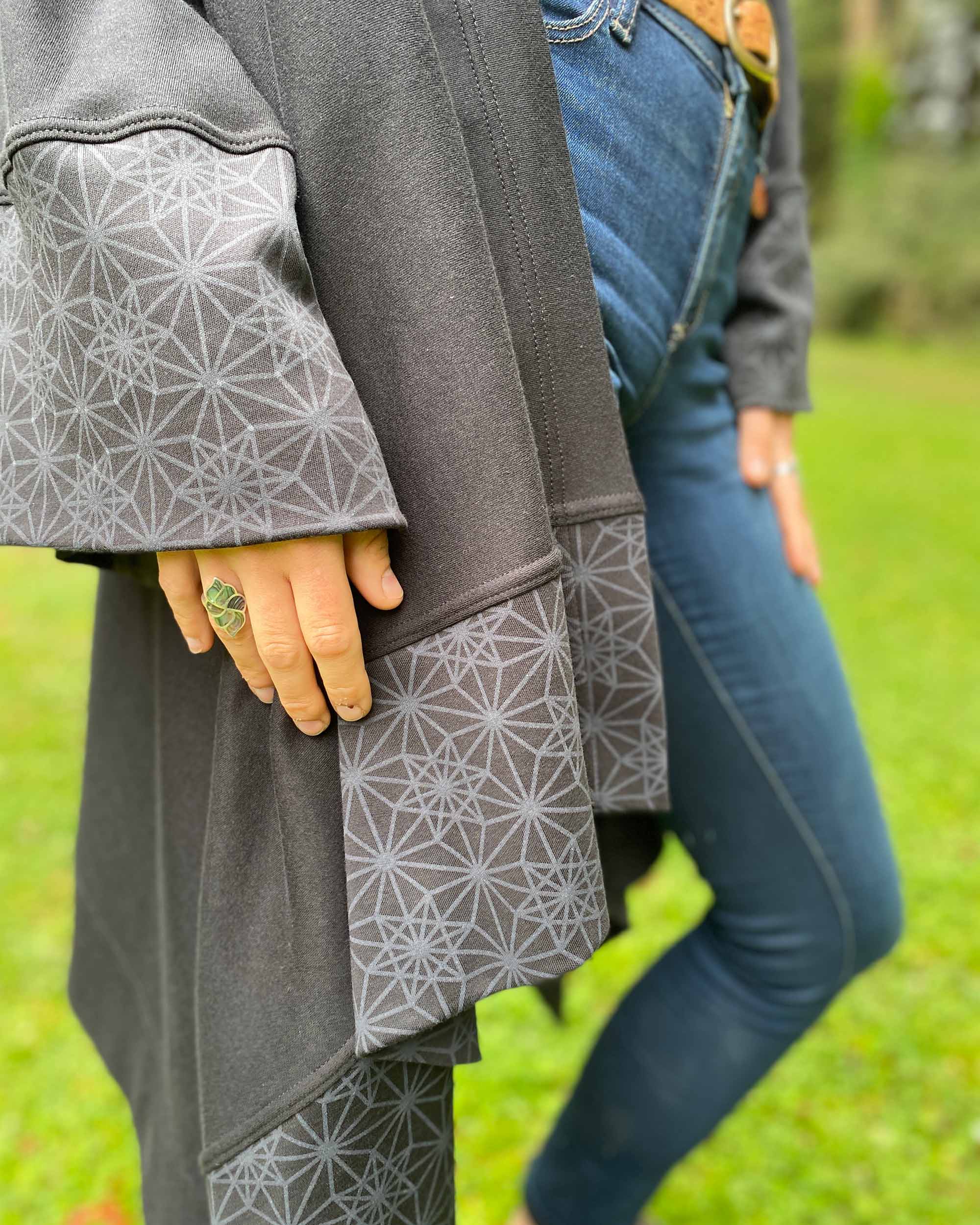 Organic cotton kimono, black with geometric printed accents, detail view of sleeve fabrics.