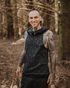 Organic cotton matching hooded tank top and shorts, black fabric with geometric print, front view on male model.