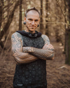 Organic cotton hooded tank top, black fabric with geometric print, front view on male model.