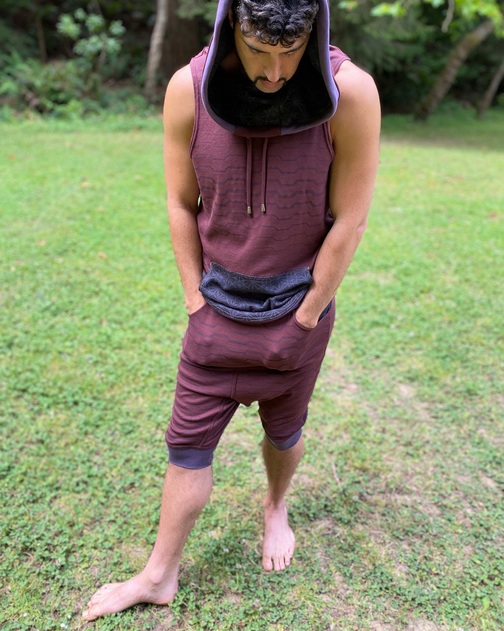 Cowl hood tank top and drop crotch shorts, brown fabric with geometric stripes, front view on male model.