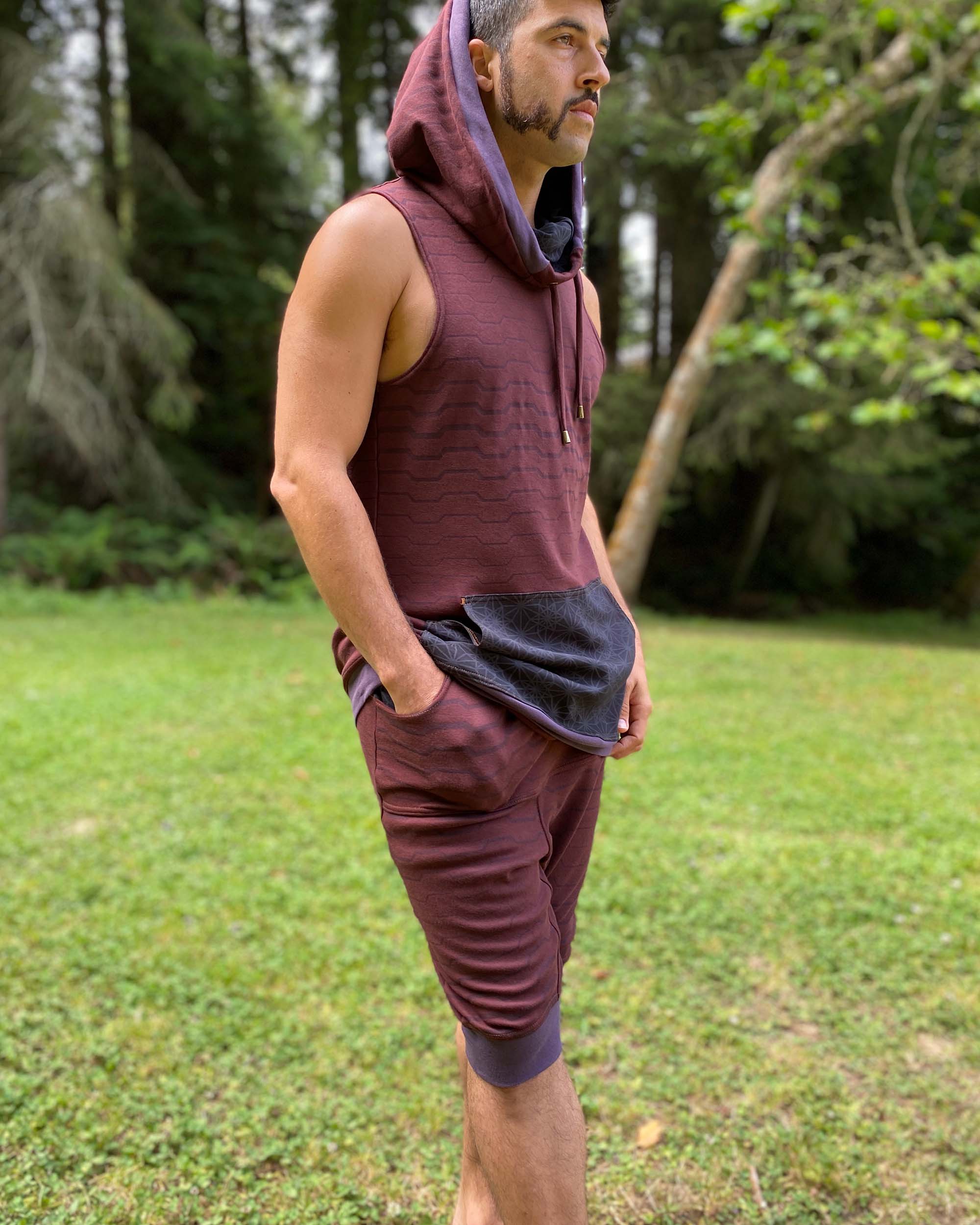 Cowl hood tank top and drop crotch shorts, brown fabric with geometric stripes, right side view on male model.