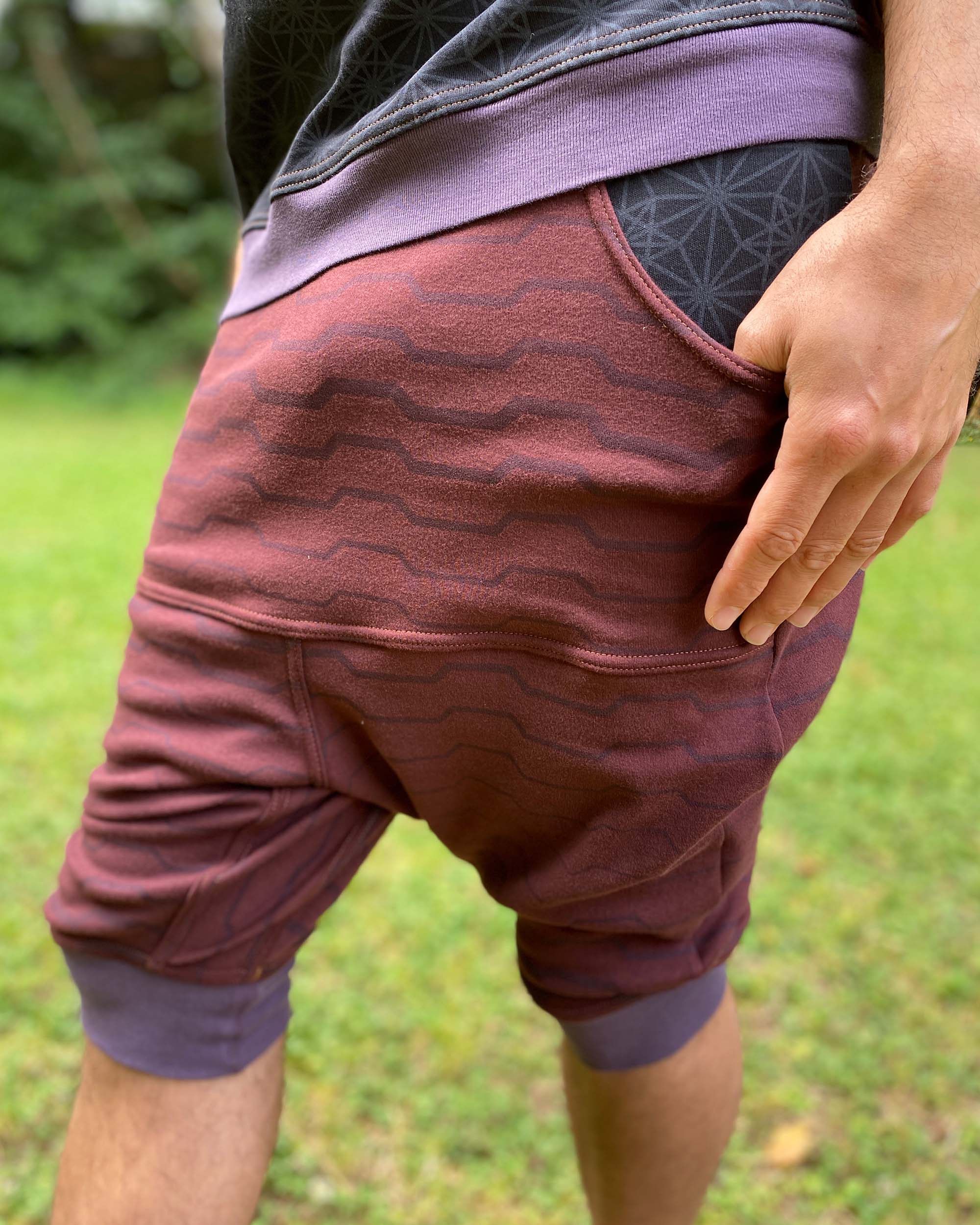 Organic cotton drop crotch shorts, reddish brown fabric with geometric stripes, detail view of the fabric.