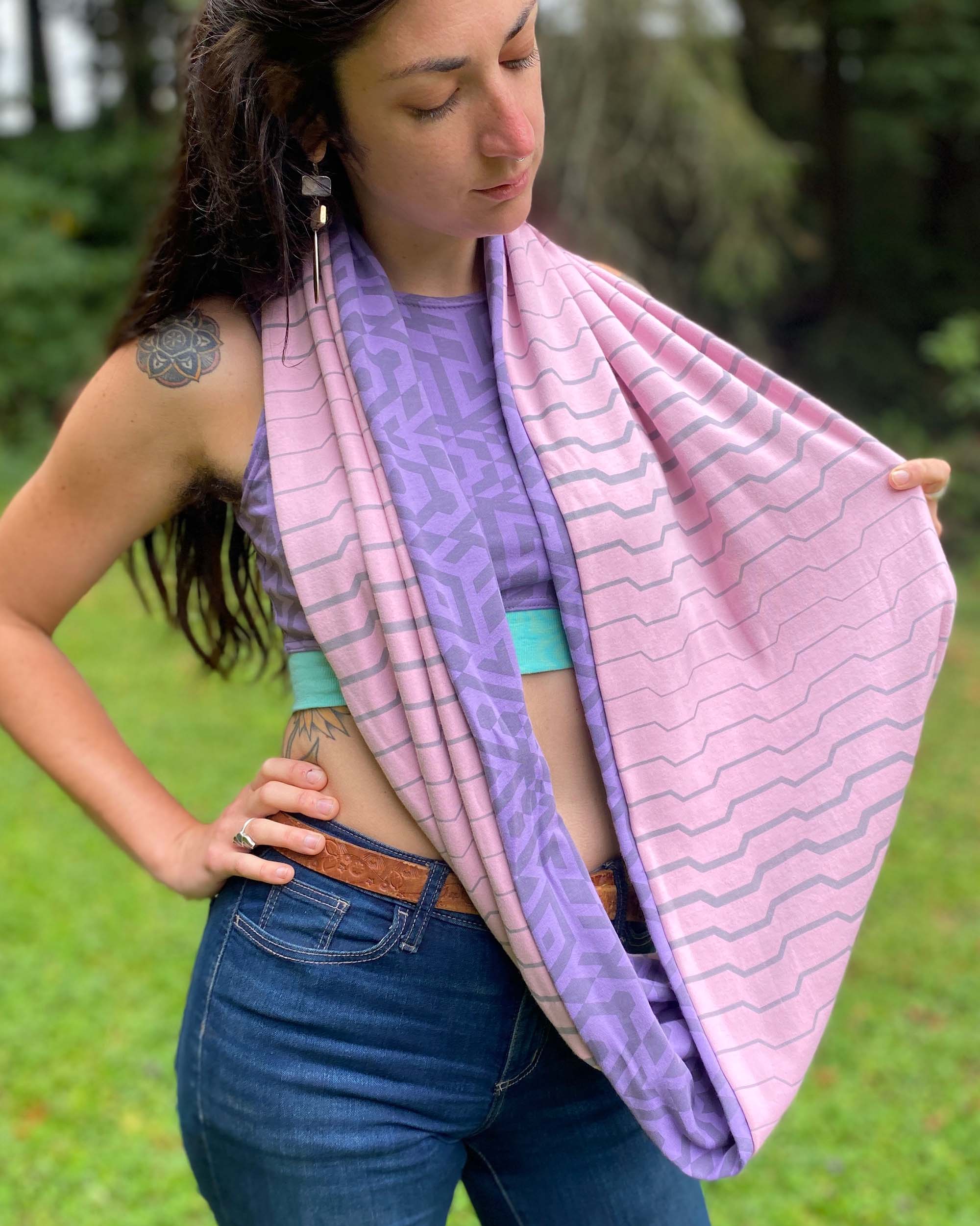 Lavender and pink organic cotton infinity scarf with geometric printed fabric, front view on female model.