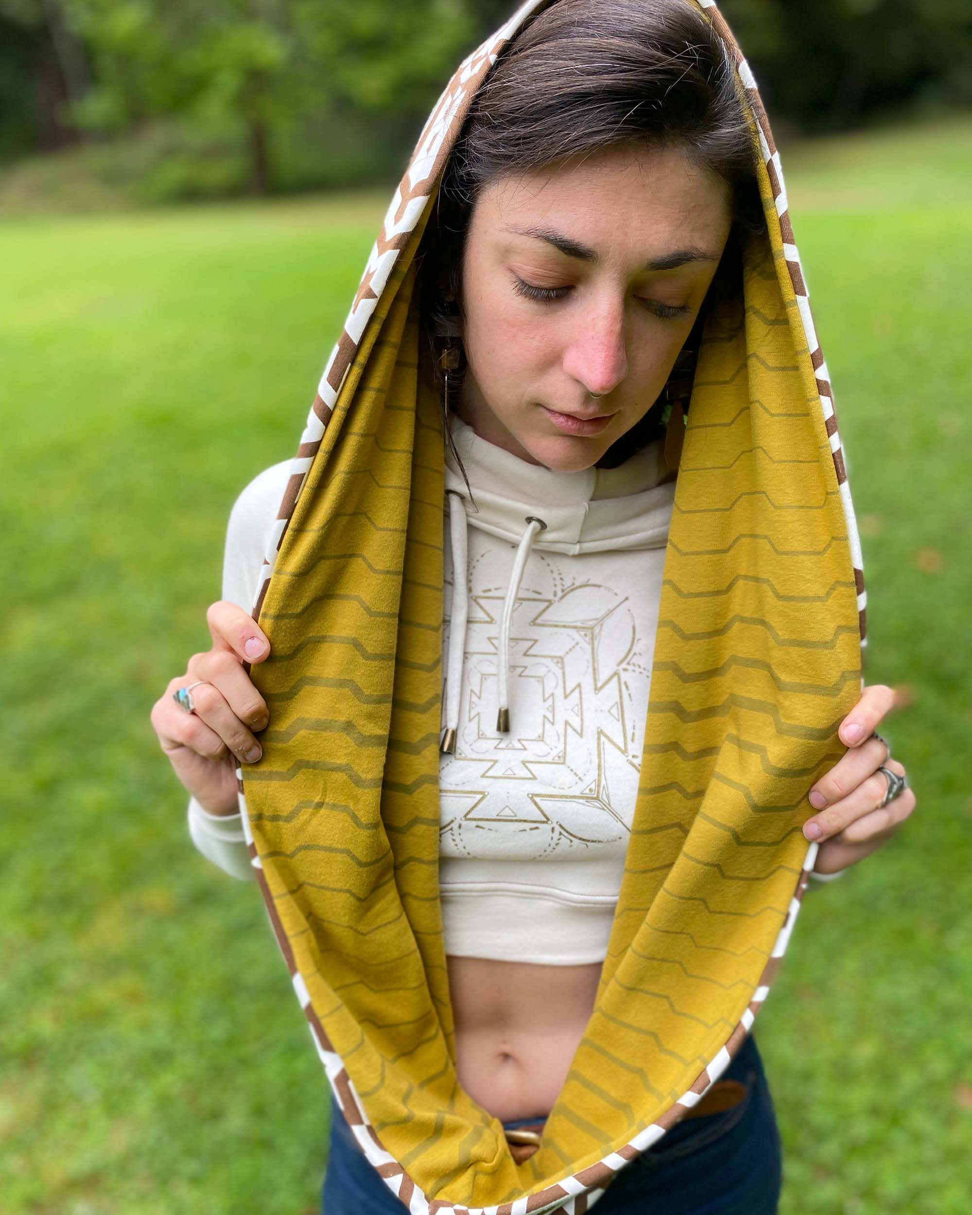 Un-dyed and yellow organic cotton infinity scarf with geo printed fabric, front view on female model.