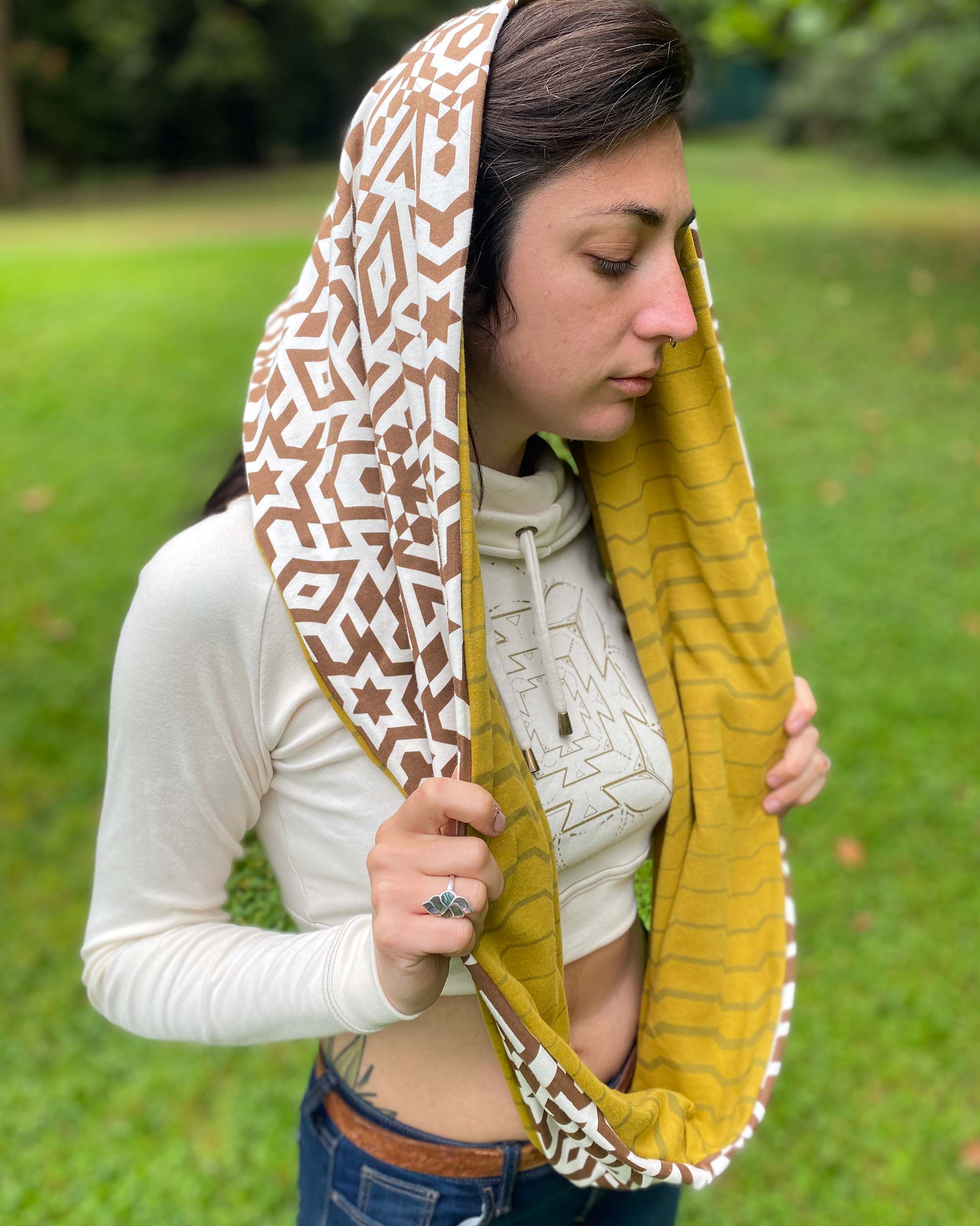Un-dyed and yellow organic cotton infinity scarf with geometric printed fabric, right side view on female model.